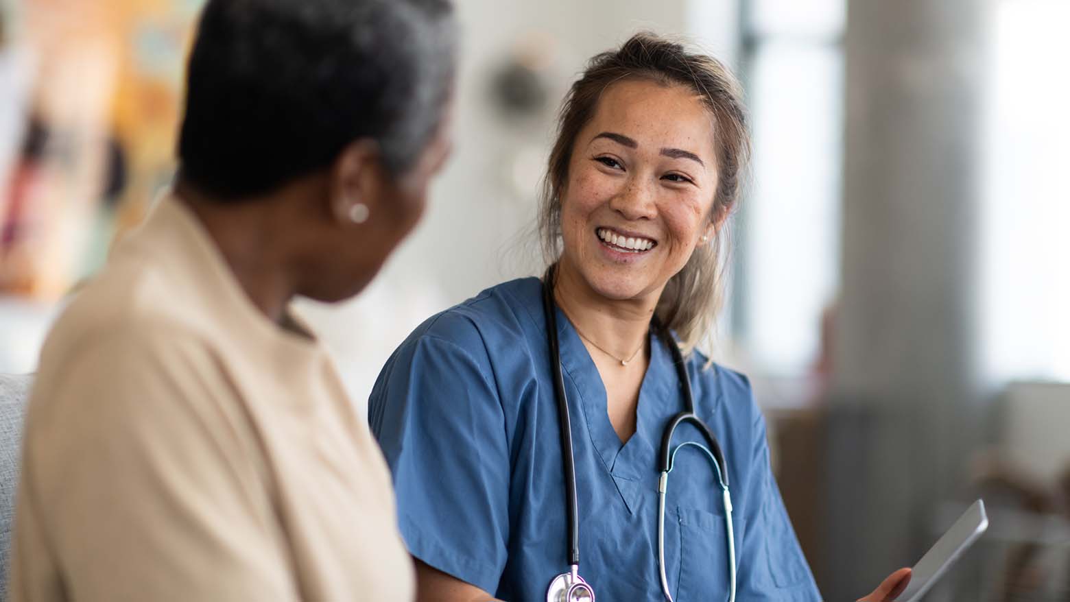 A female doctor smiles while talking to a patient