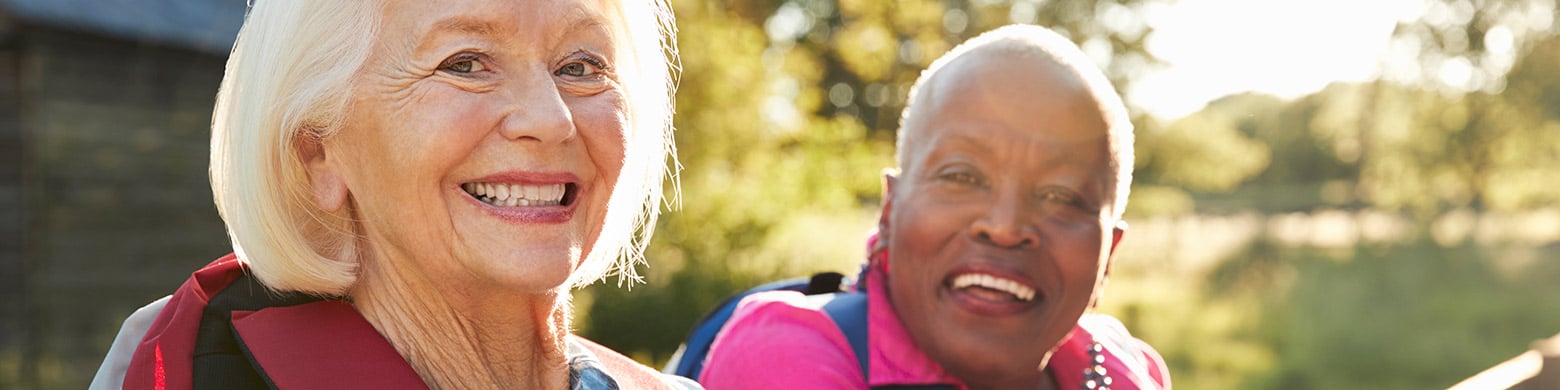 Two women stand and smile.